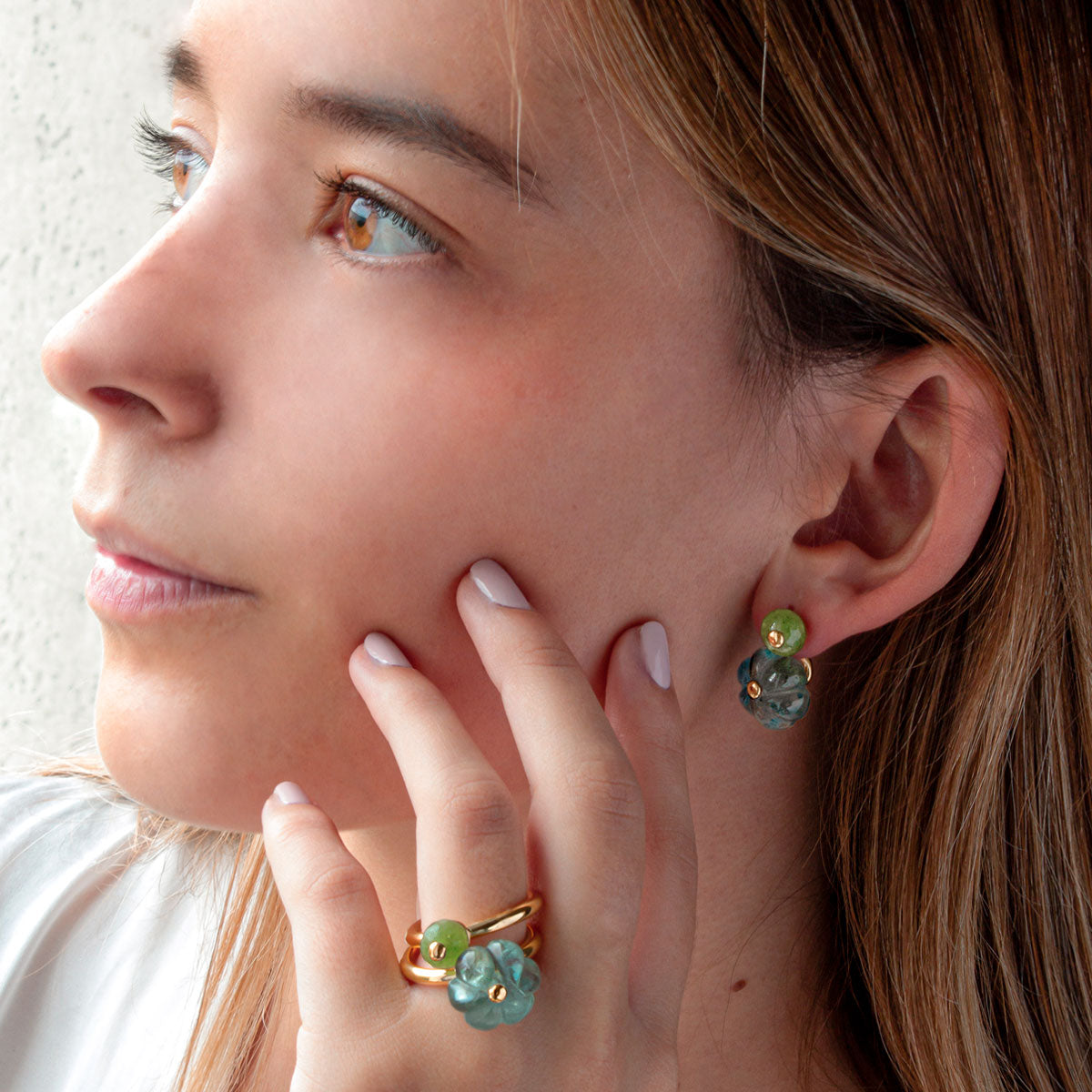 Modelo con pendientes Ear Jacket con Peridotos tallados en forma de esfera facetada de 8 mm. Fluorita verde tallados en forma de calabaza de 14mm. Oro Vermeil amarillo: Plata de 925 milésimas bañada con 3 micras de oro amarillo de 18 quilates.