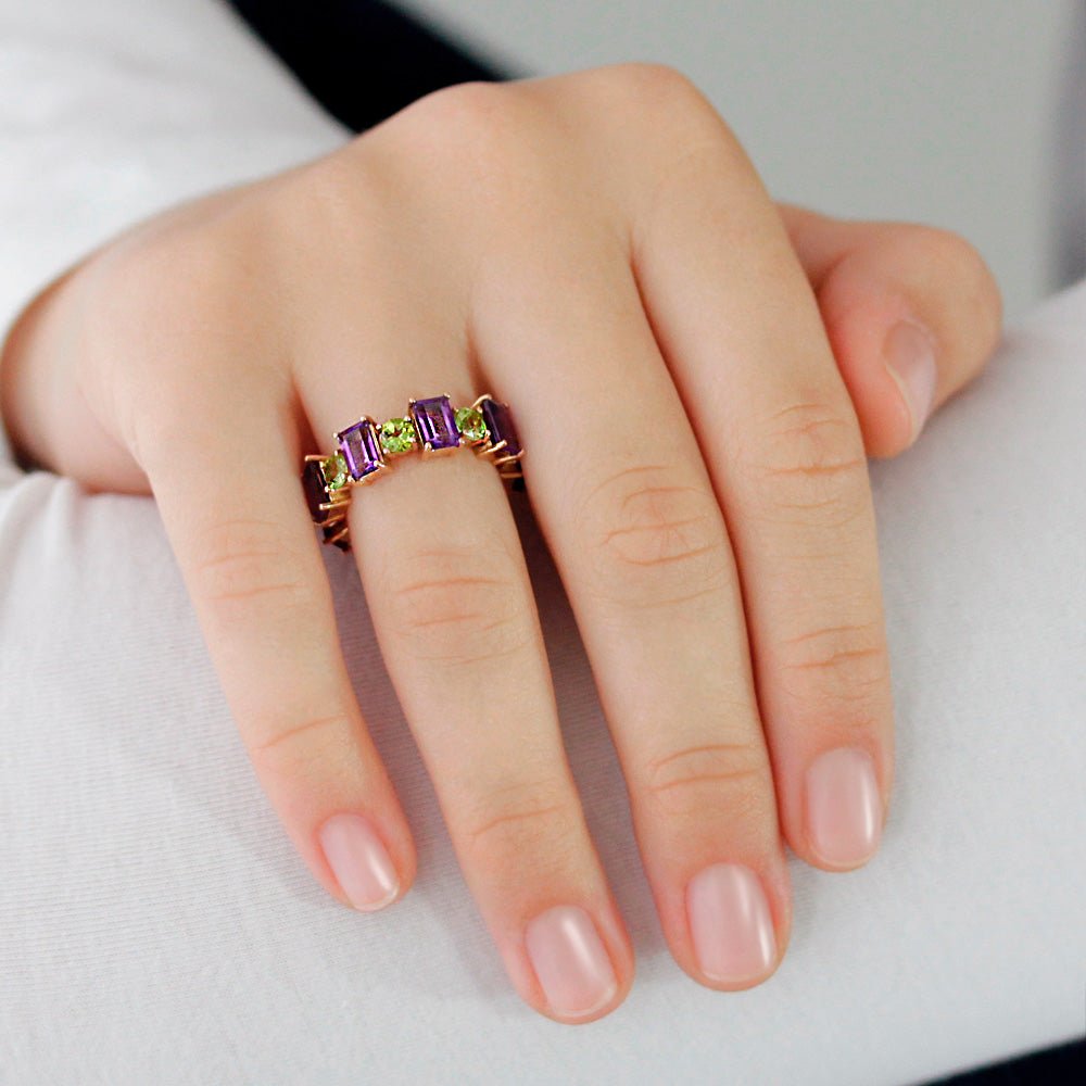 Mano con Anillo tipo eternity de Oro rosa de 750 milésimas. 8 amatistas talla octogonal de 6 x 4 mm y 8 peridotos talla redonda facetada de 4 mm.