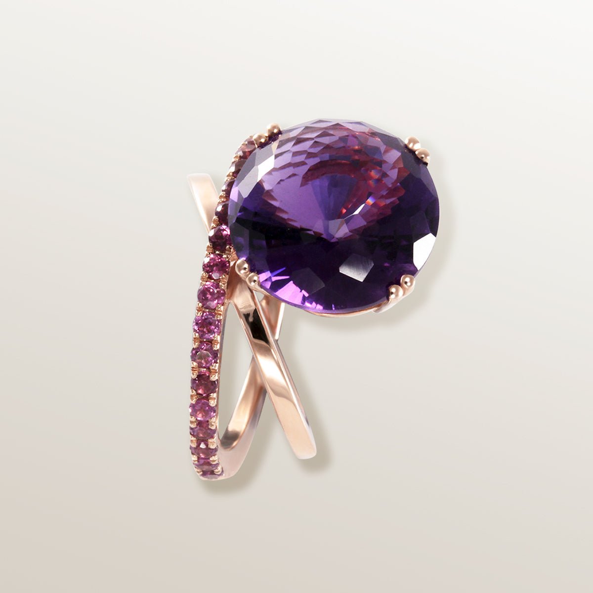 Anillo de oro rosa de 750 milésimas con dos órbitas cuajadas de Amatistas y en el centro una gran piedra Amatista en talla fantasía.