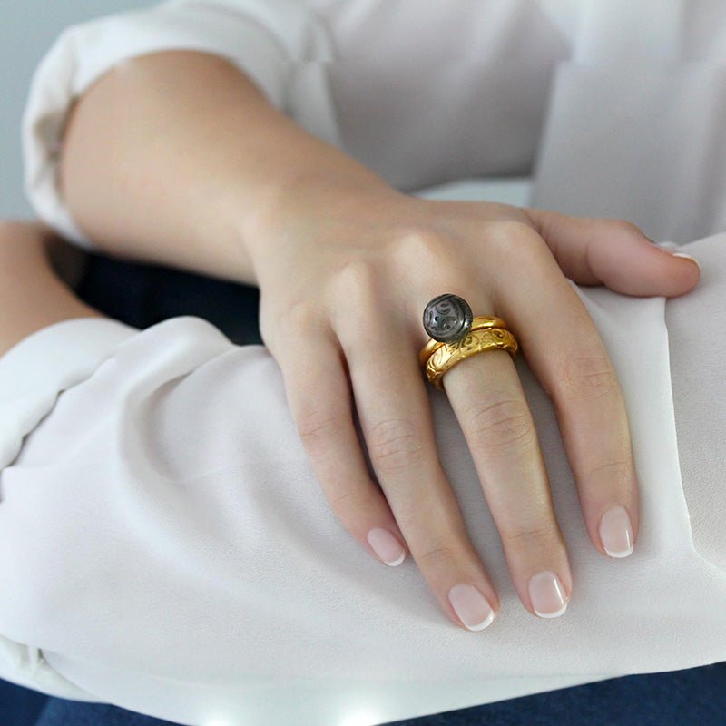 Mano con Anillo de Oro Vermeil amarillo: Plata de 925 milésimas recubierta de 3 micras de oro amarillo. Perla de Tahití de 12mm grabada a mano con motivos maorís.