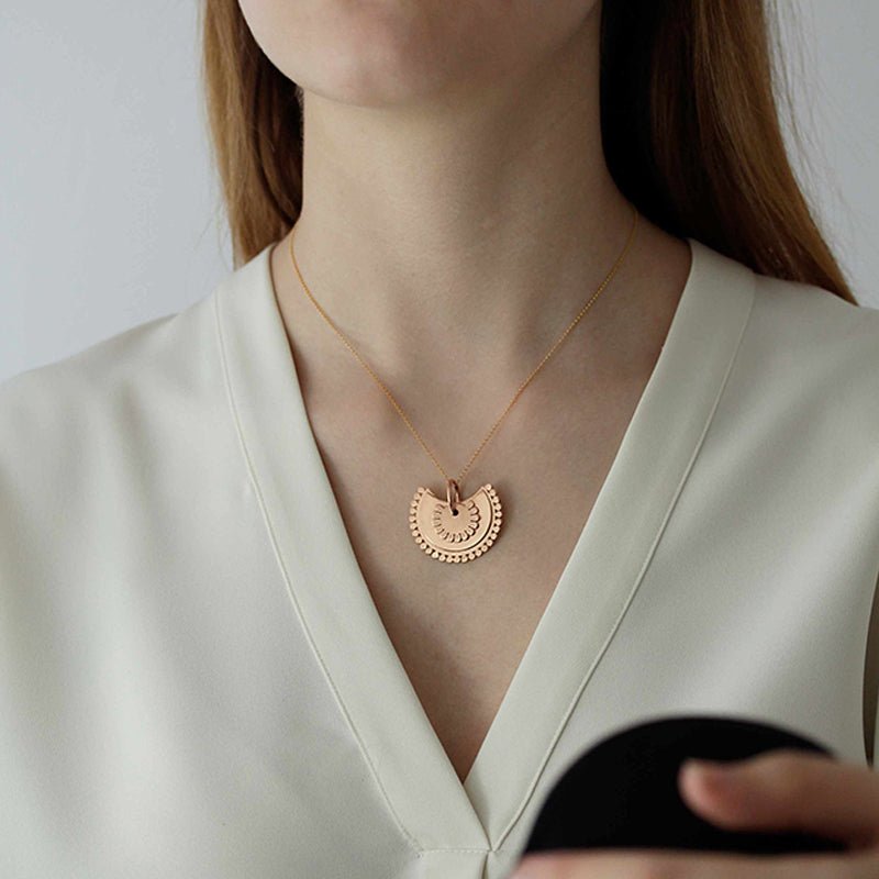 Modelo luciendo el Colgante en forma de flor semicircular de Vermeil: plata de 925 milésimas bañada con 3 micras de oro de 18 quilates.