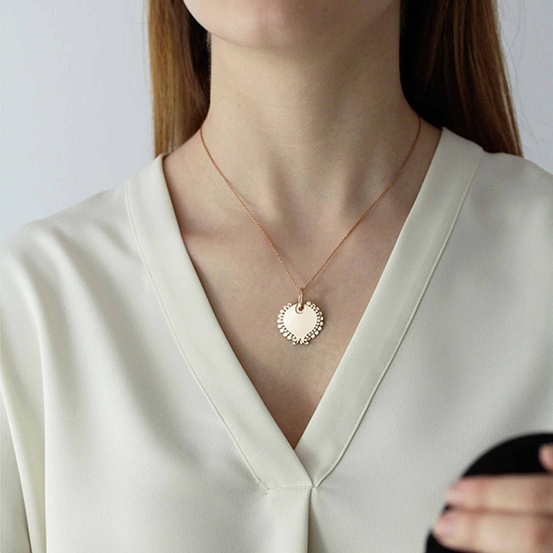 Modelo luciendo el Colgante en forma de estilizado tulipán de Oro Vermeil rosa, cortado a láser y terminado a mano.