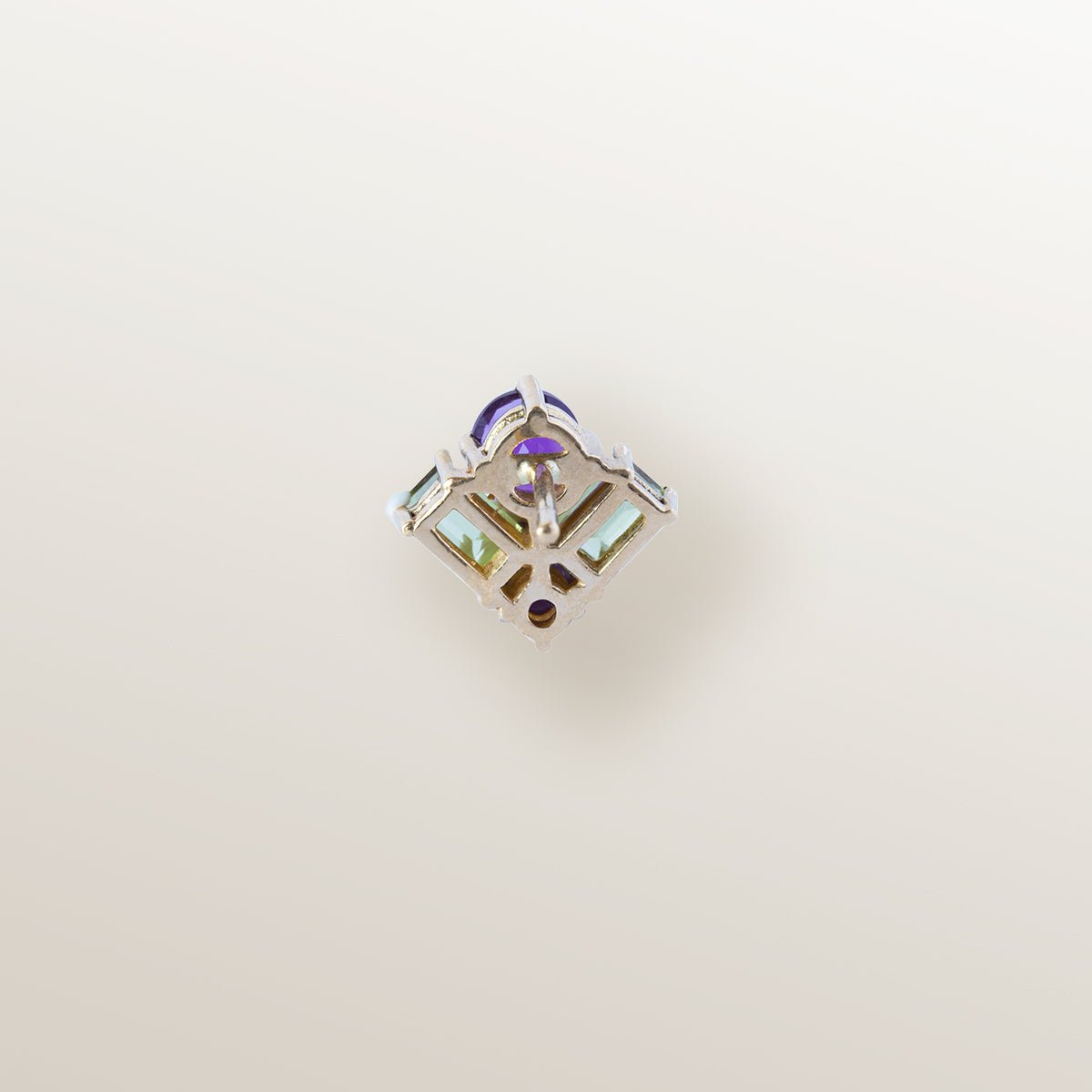 Pendiente de oro amarillo en forma de ala delta, cuajado de amatistas y peridotos.