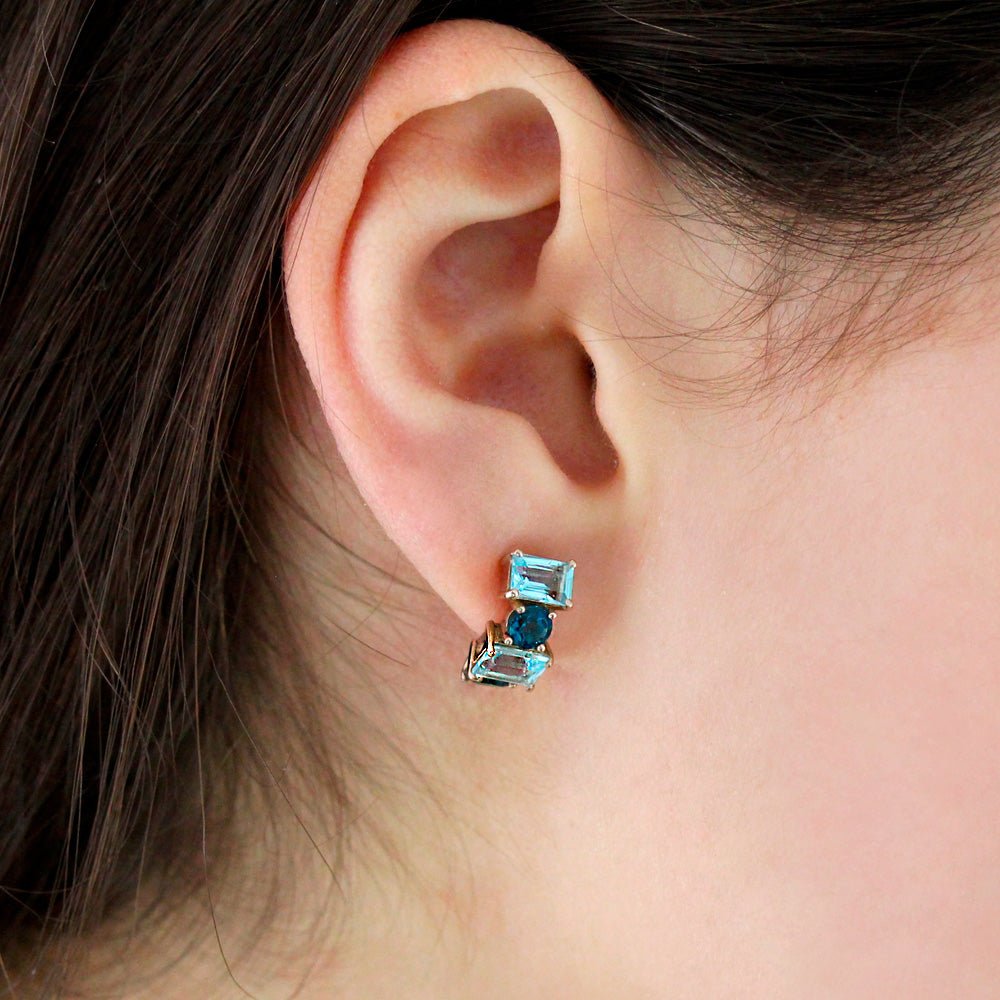 Modelo con Pendientes tipo medio aro o criolla eternity de Oro rosa de 750 milésimas. 4 topacios azules talla octogonal de 6 x 4mm y 4 topacios azules London blue talla redonda facetada de 4mm.