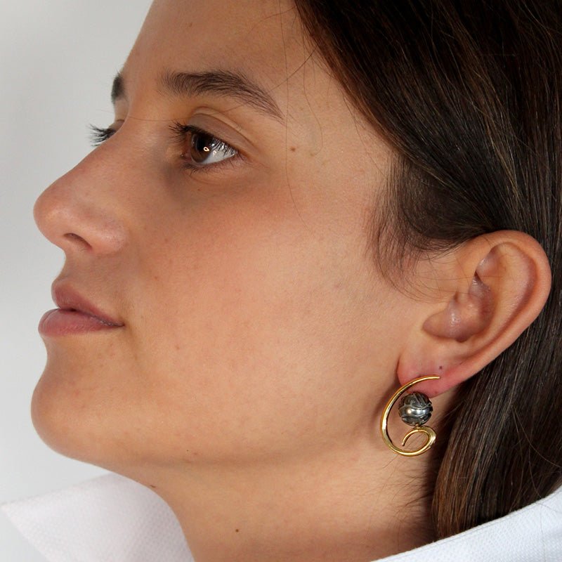 Modelo con Pendientes de Oro Vermeil amarillo: Plata de 925 milésimas recubierta de 3 micras de oro amarillo.
Perlas de Tahití de 10 mm grabadas a mano con motivos Maorís.