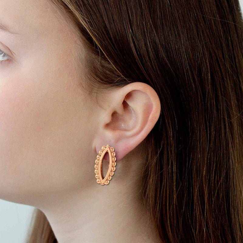 Modelo luciendo los Pendientes de Oro Vermeil rosa: Plata de 925 milésimas, rodeada de 16 pequeñas esferas, y recubiertos con 3 micras de oro rosa de 18 quilates.