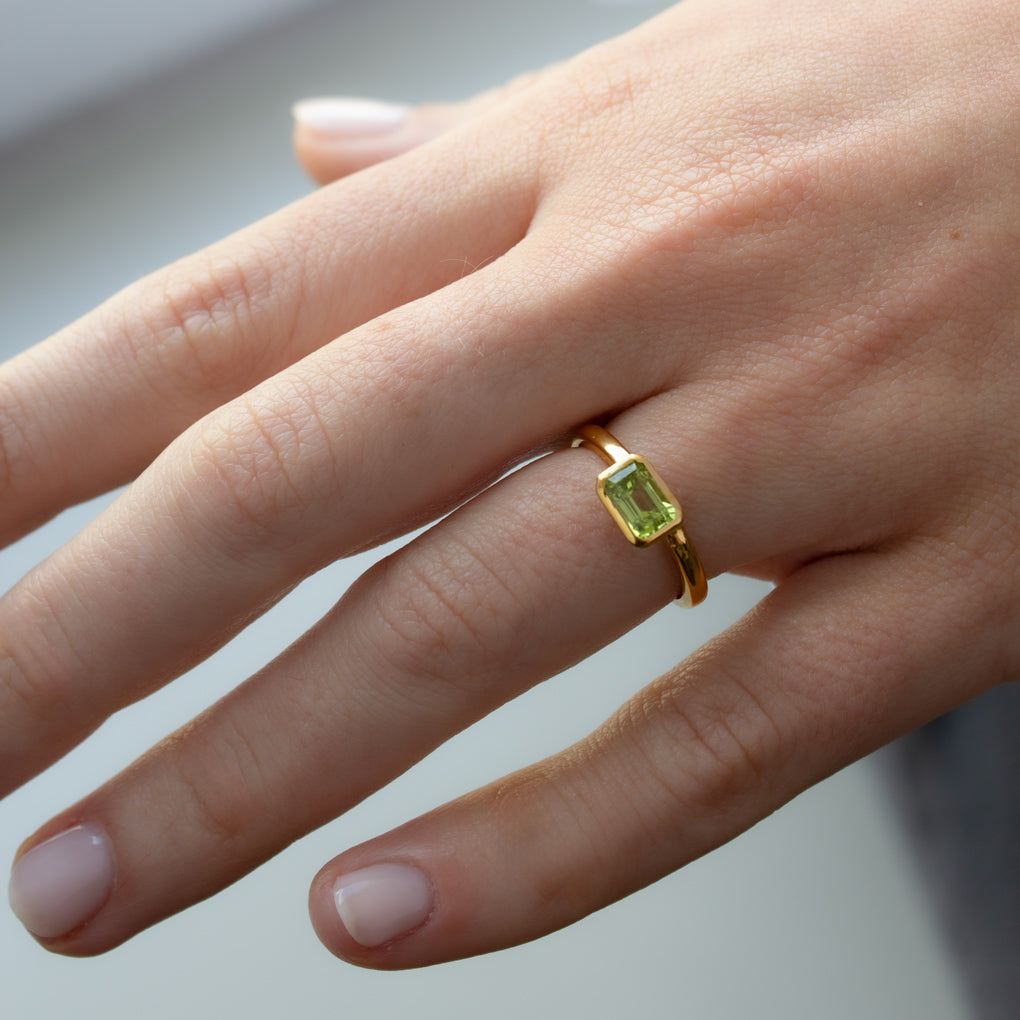 Mano con Anillo de Oro Vermeil amarillo, y peridoto natural tallado en forma octogonal.