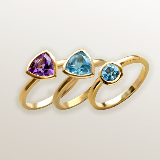 Combinación de 3 anillos de Oro Vermeil amarillo, con piedras amatista natural tallada en forma triangular  y topacio azul natural en forma triangular  y brillante.