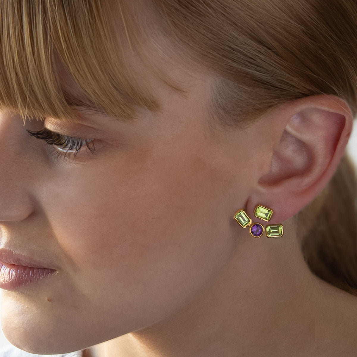 Modelo con Pendiente desmontable “ear jacket” de Oro Vermeil amarillo, 3 peridotos naturales talla octogonal de 6 x 4mm y 1 amatista talla brillante de 5mm de diámetro.