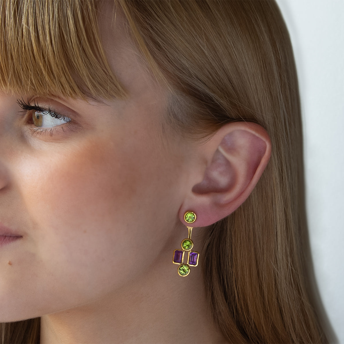 Modelo con Pendientes desmontables tipo “ear jacket” de Oro Vermeil amarillo, 6 peridotos naturales talla brillante de 5mm de diámetro y 4 amatistas talla octogonal de 6 x 4mm.