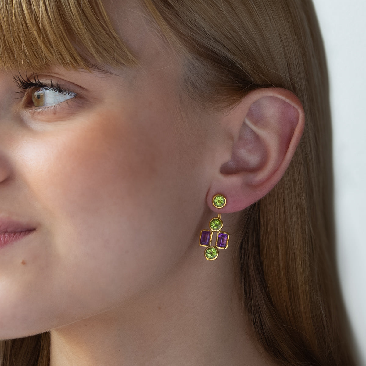 Modelo con Pendientes desmontables tipo “ear jacket” de Oro Vermeil amarillo, 6 peridotos naturales talla brillante de 5mm de diámetro y 4 amatistas talla octogonal de 6 x 4mm.