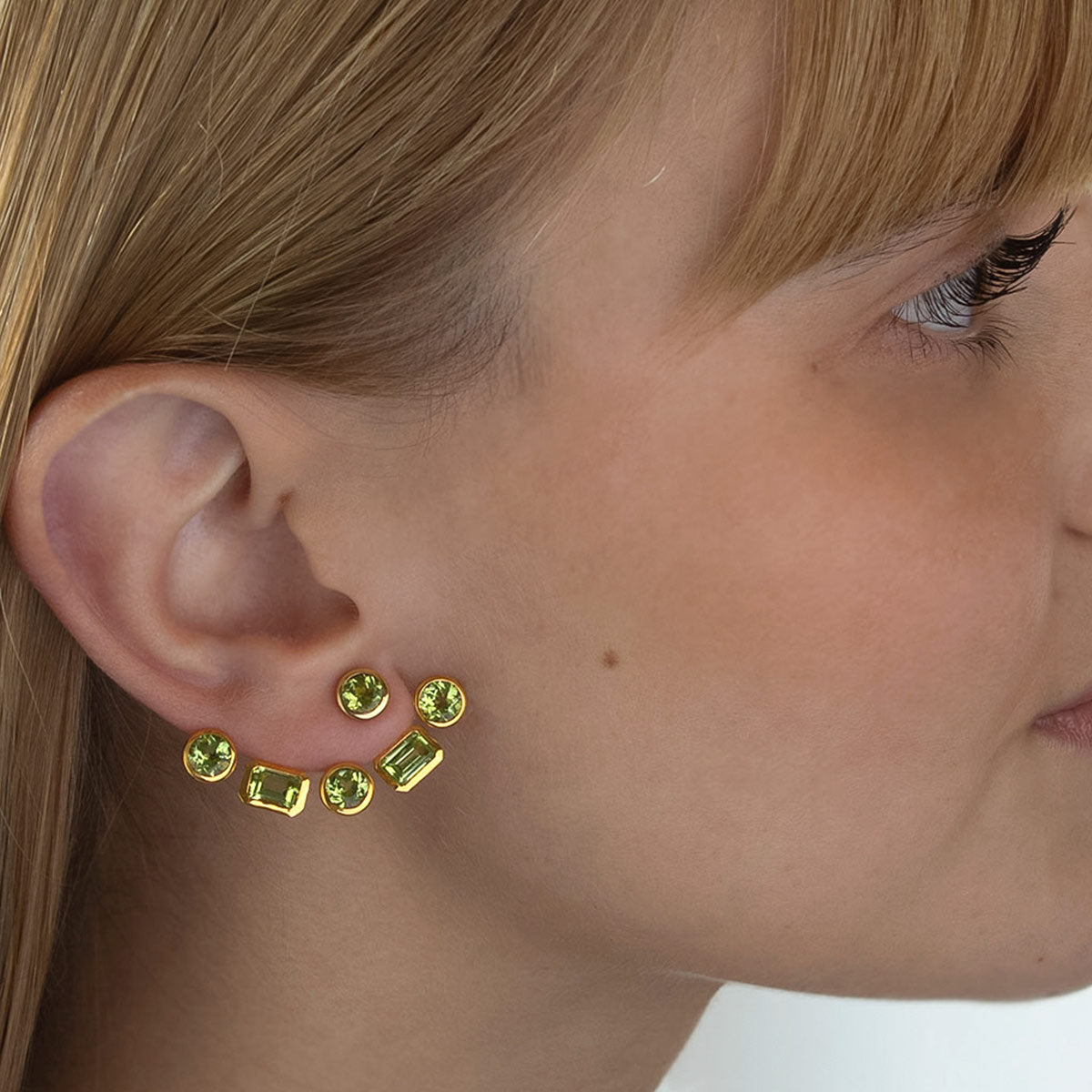 Modelo con Pendiente desmontable "ear jacket" de Oro Vermeil amarillo, con 3 peridotos naturales talla octogonal de 6 x 4mm y 3 peridotos talla brillante de 5mm de diámetro.