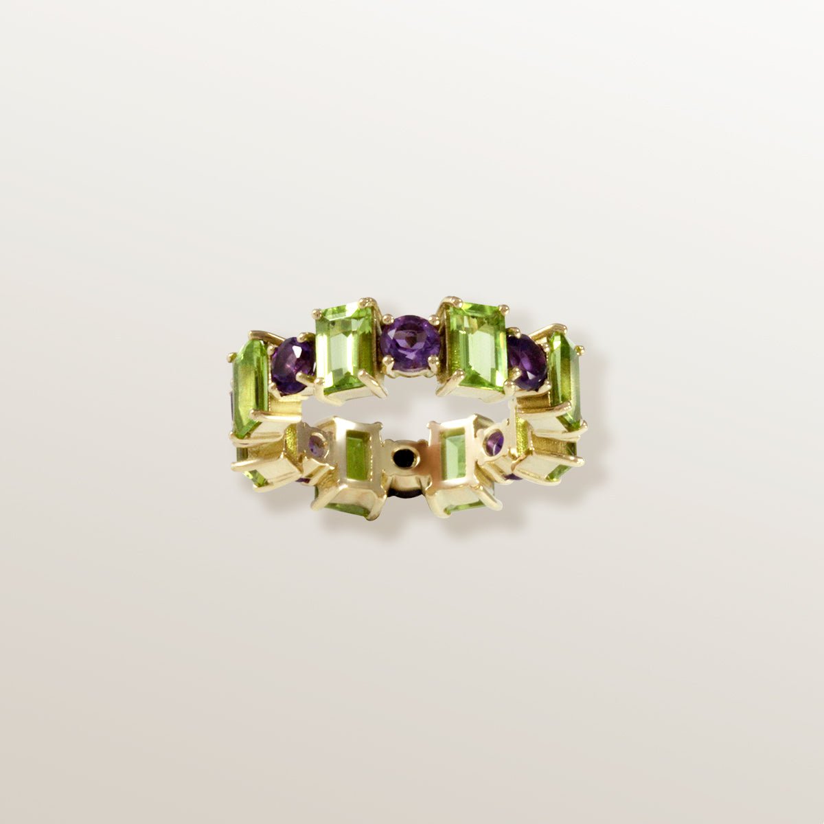 Anillo tipo eternity de Oro amarillo de 750 milésimas. 8 peridotos talla octogonal de 6 x 4mm y 8 amatistas talla redonda facetada de 4mm.