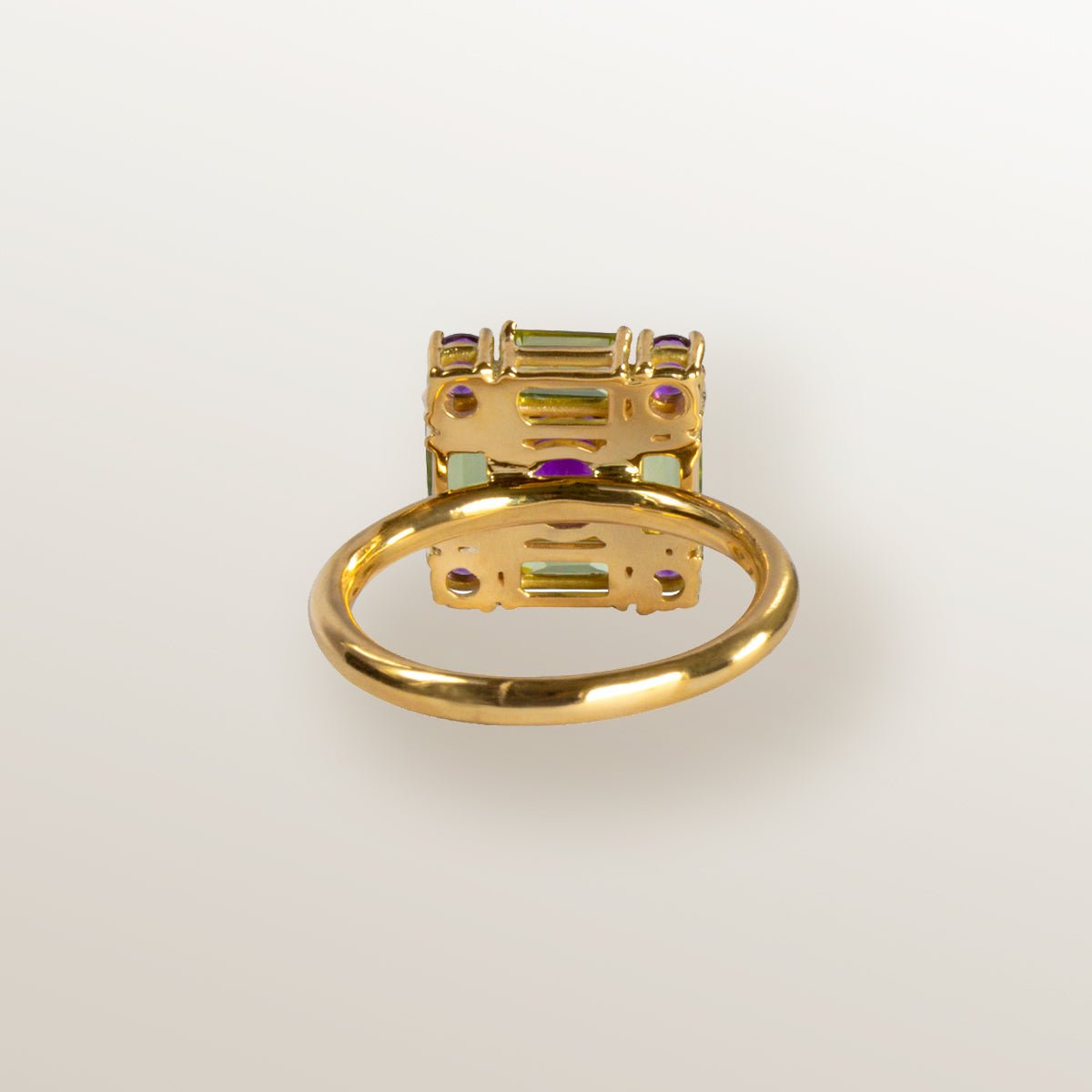 Anillo de oro amarillo con forma cuadrada cuajada de amatistas y peridotos.