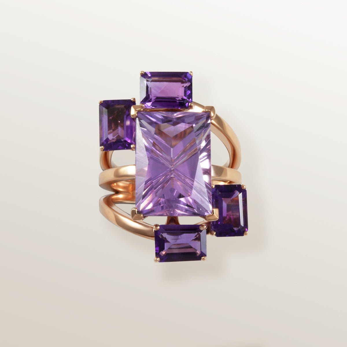 Anillo de oro rosa con Amatista color lila en talla Laser Cut rectangular en el centro y 4 piedras laterales Amatista color morado intenso.