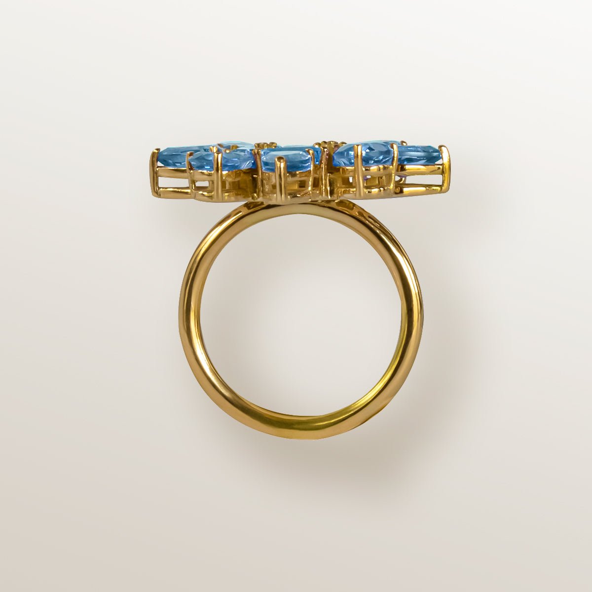 Anillo de oro amarillo con forma de estrella cuajada de topacios azules en 2 tonos.