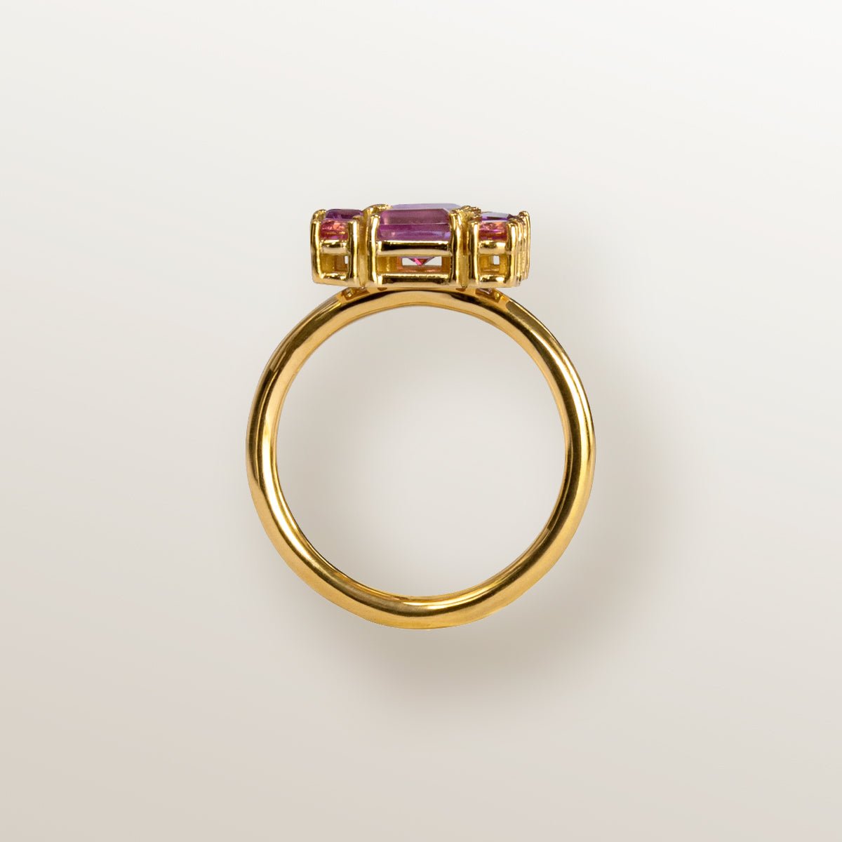 Anillo de oro amarillo con forma cuadrada cuajada de topacios rosa y amatistas.