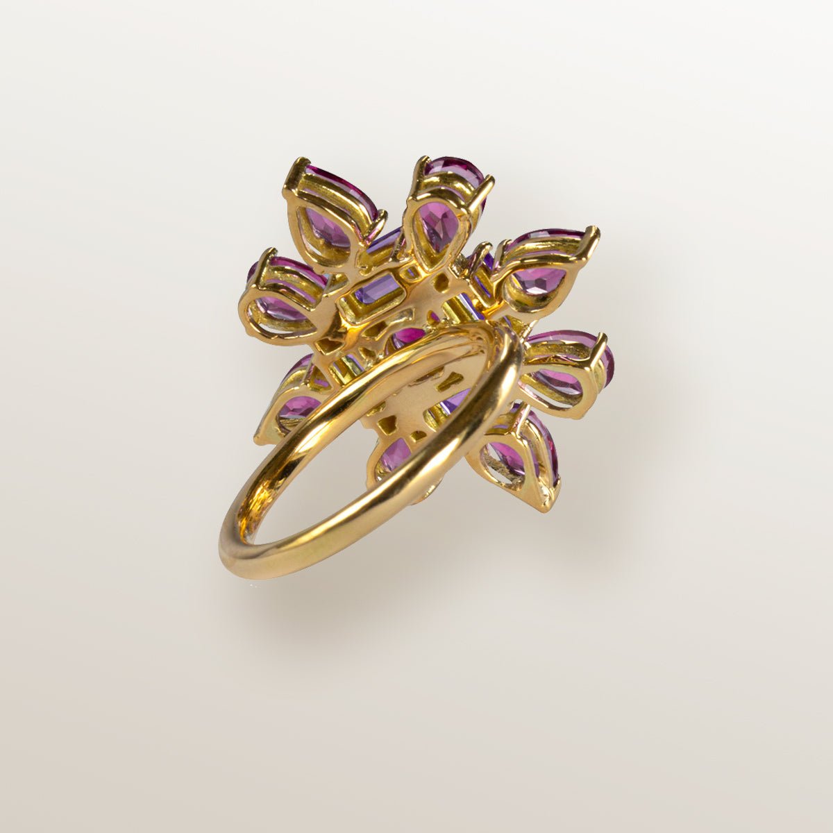 Anillo de oro amarillo con forma de estrella cuajada de topacios rosa y amatistas.