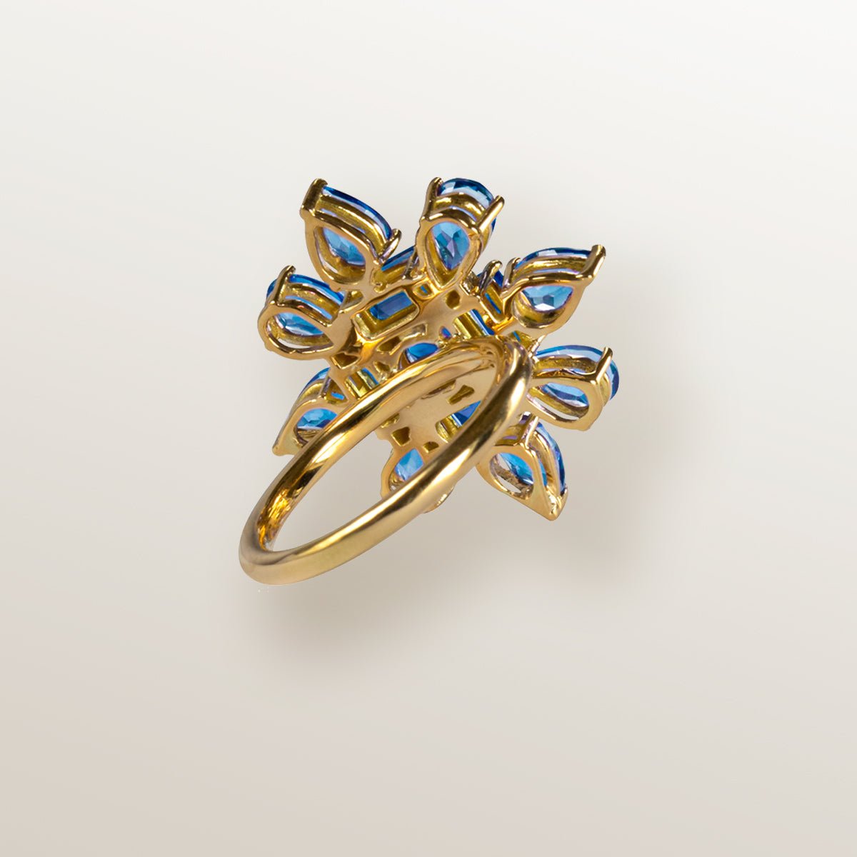 Anillo de oro amarillo con forma de estrella cuajada de topacios azules en 2 tonos.