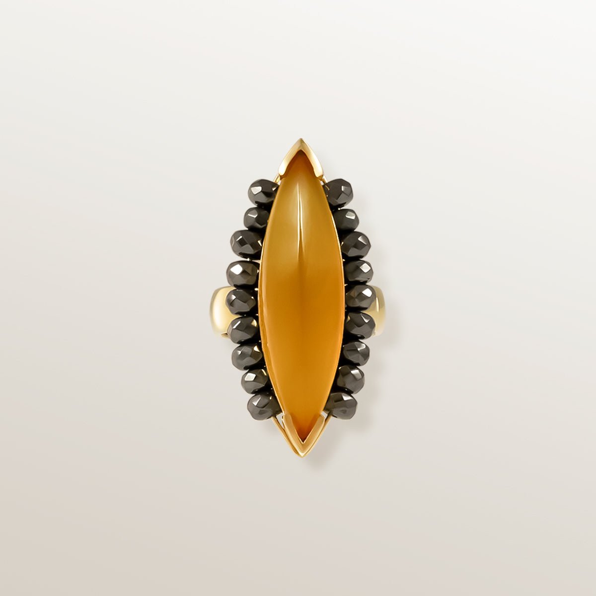 Anillo de Oro Vermeil amarillo, con un Ágata color miel talla marquise cabujón. Rodeada de 18 Hematites facetados.