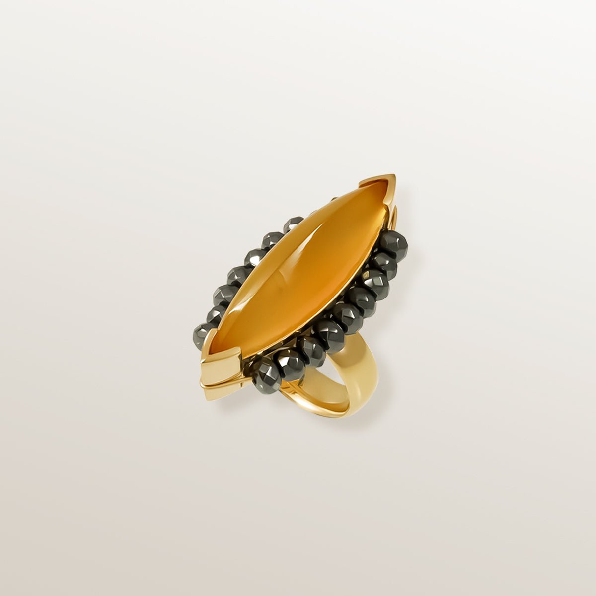 Anillo de Oro Vermeil amarillo, con un Ágata color miel talla marquise cabujón. Rodeada de 18 Hematites facetados.