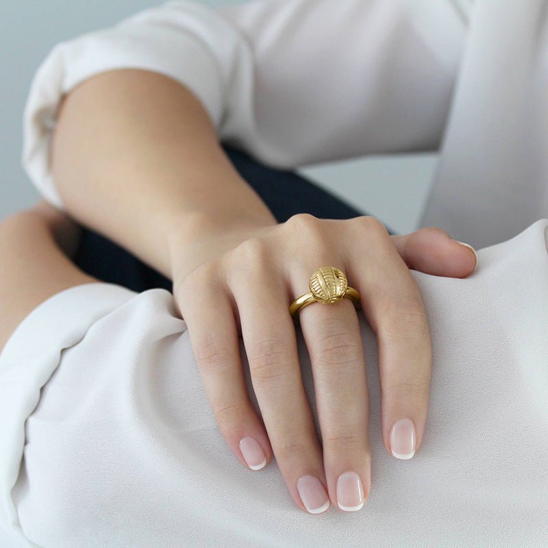 Mano con Anillo de Oro Vermeil amarillo, con esfera grabada con motivos de tatuajes Maorís. 