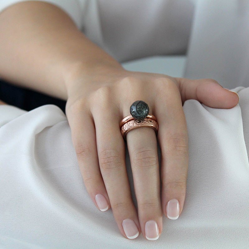 Mano con Anillo de Oro Vermeil rosa, con una perla de Tahití grabada a mano con motivos maorís.