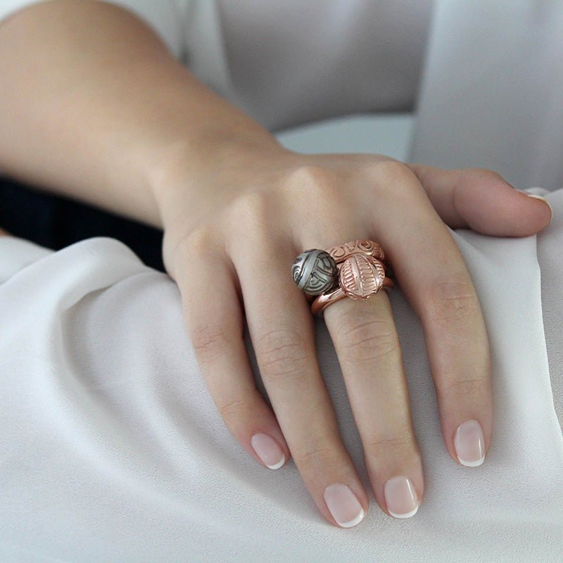 Mano con Anillo de Oro Vermeil rosa, con una perla de Tahití grabada a mano con motivos maorís.