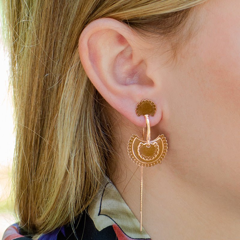 Modelo luciendo los pendientes con motivo en forma de flor semicircular y detalle de cadena, de Vermeil de oro rosa de 18 quilates. 