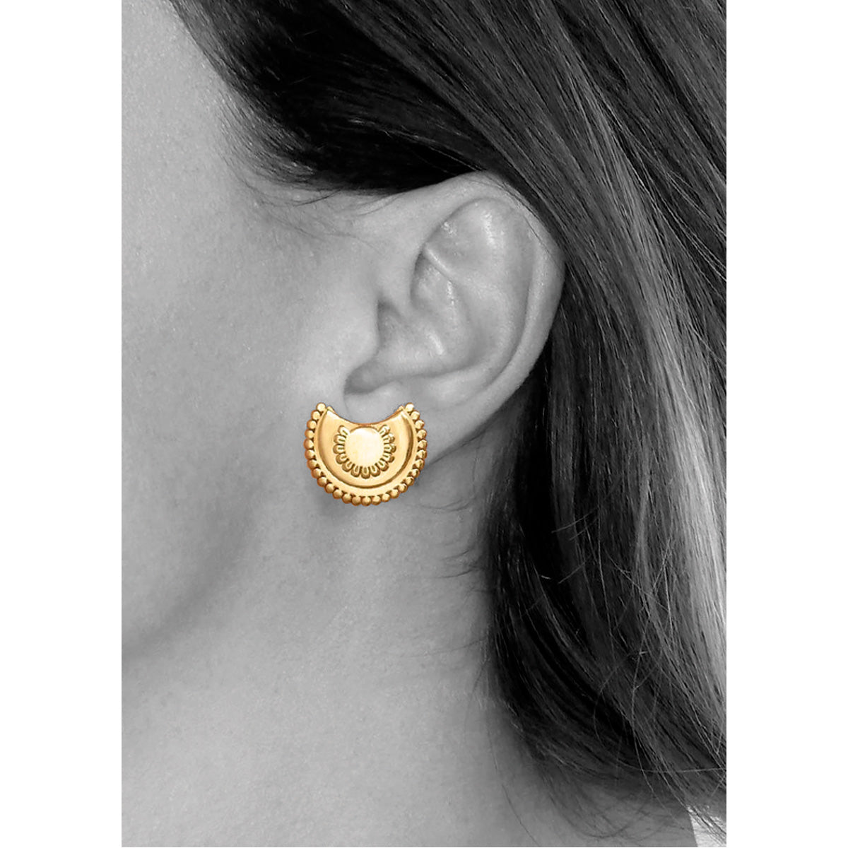 Modelo luciendo los pendientes con motivo en forma de flor semicircular, de Vermeil* de oro amarillo de 18 quilates.